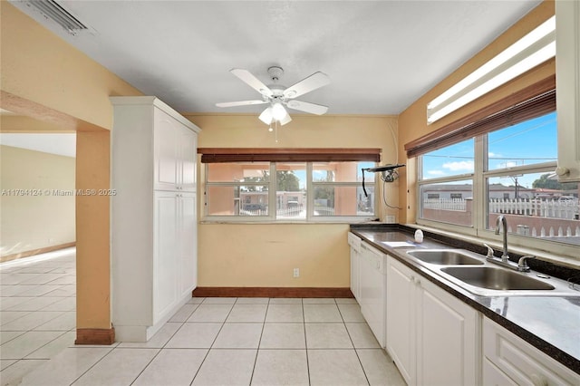 4241 W 1st Ave, Hialeah, FL 33012 - kitchen with white dishwasher, ceiling fan, a sink, white cabinetry, and light tile patterned floors