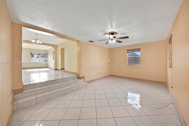 4241 W 1st Ave, Hialeah, FL 33012 - spare room with visible vents, a textured ceiling, ceiling fan with notable chandelier, and light tile patterned floors