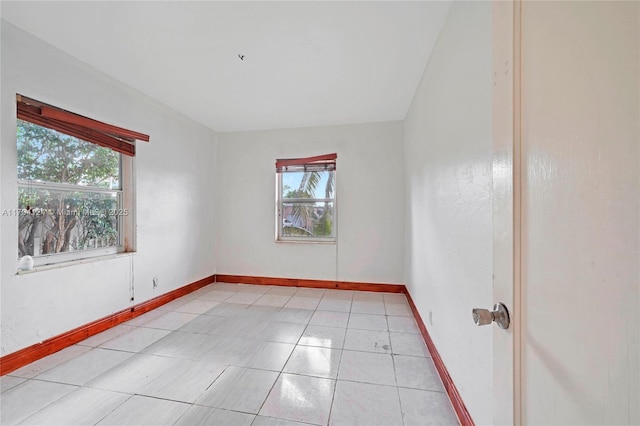 4241 W 1st Ave, Hialeah, FL 33012 - unfurnished room with a healthy amount of sunlight, baseboards, and light tile patterned floors