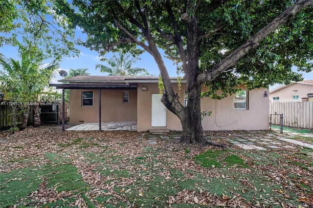 4241 W 1st Ave, Hialeah, FL 33012 - rear view of property featuring a fenced backyard, a patio, and stucco siding