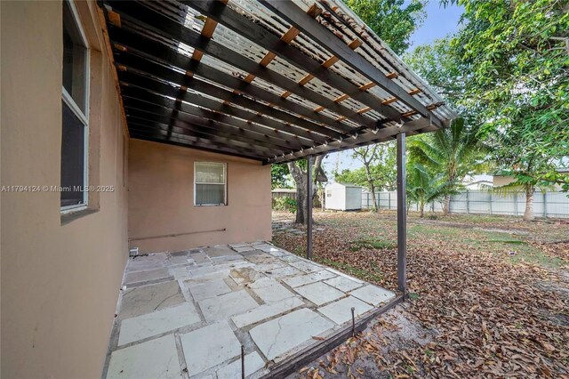 4241 W 1st Ave, Hialeah, FL 33012 - view of patio / terrace featuring a storage unit, a pergola, fence, and an outbuilding
