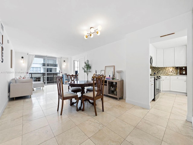 6039 Collins Ave Unit 1015, Miami Beach, FL 33140 - dining space with light tile patterned floors and visible vents