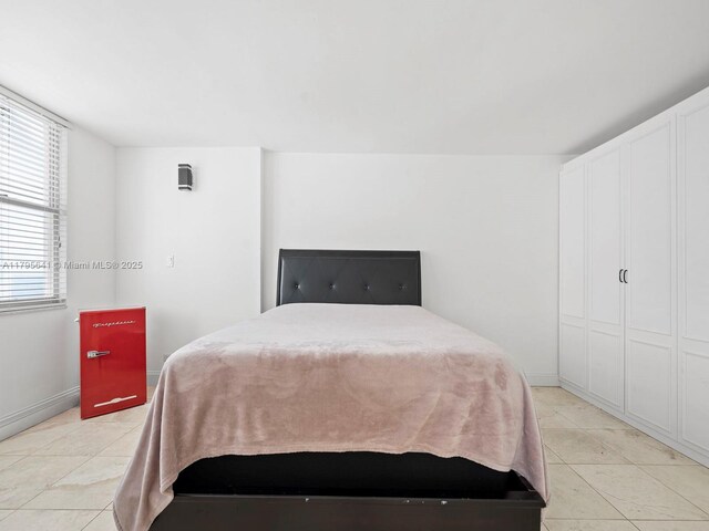 6039 Collins Ave Unit 1015, Miami Beach, FL 33140 - bedroom featuring baseboards and light tile patterned flooring