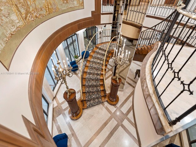 6039 Collins Ave Unit 1015, Miami Beach, FL 33140 - staircase with arched walkways, a notable chandelier, and a towering ceiling