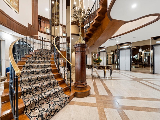 6039 Collins Ave Unit 1015, Miami Beach, FL 33140 - stairs with recessed lighting, elevator, decorative columns, and a towering ceiling
