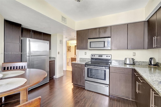3300 NE 191st St Unit 07, Aventura, FL 33180 - kitchen featuring appliances with stainless steel finishes, dark brown cabinetry, dark wood-style floors, and light stone counters