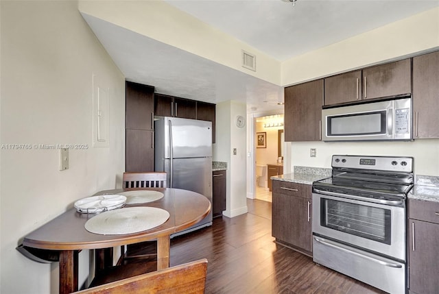 3300 NE 191st St Unit 07, Aventura, FL 33180 - kitchen featuring stainless steel appliances, dark brown cabinets, dark wood-type flooring, and baseboards