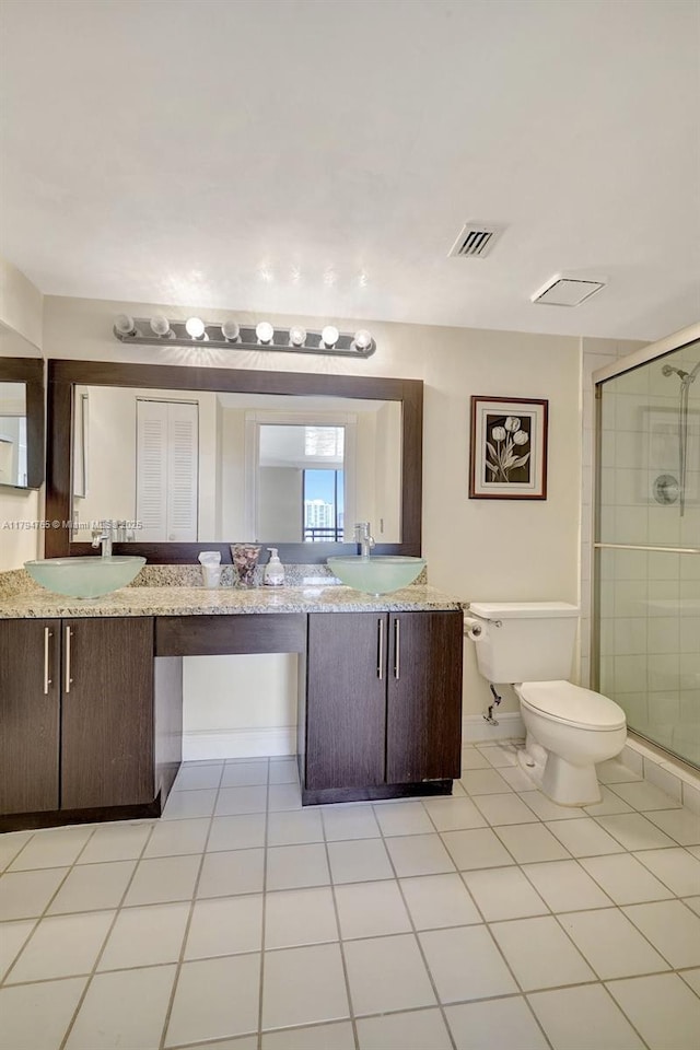 3300 NE 191st St Unit 07, Aventura, FL 33180 - bathroom featuring toilet, a stall shower, double vanity, and tile patterned flooring