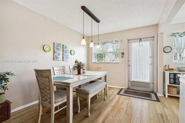 2164 NE 1st Way Unit 103, Boynton Beach, FL 33435 - dining room featuring light wood-style flooring, a textured ceiling, and baseboards