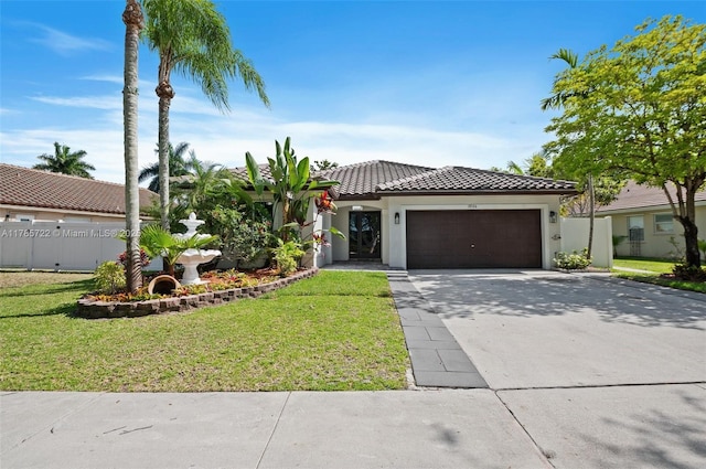mediterranean / spanish home featuring stucco siding, an attached garage, driveway, and a front lawn