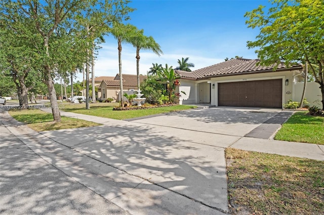 mediterranean / spanish home featuring concrete driveway, an attached garage, a tile roof, and stucco siding