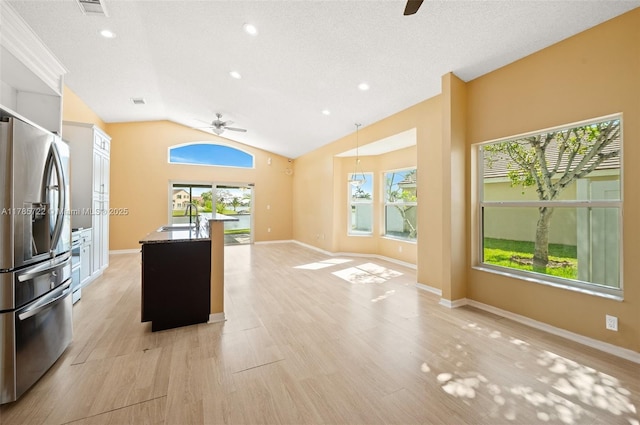 kitchen with a sink, ceiling fan, stainless steel refrigerator with ice dispenser, and a wealth of natural light