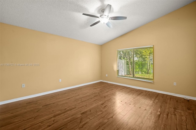empty room featuring ceiling fan, a textured ceiling, baseboards, wood finished floors, and lofted ceiling