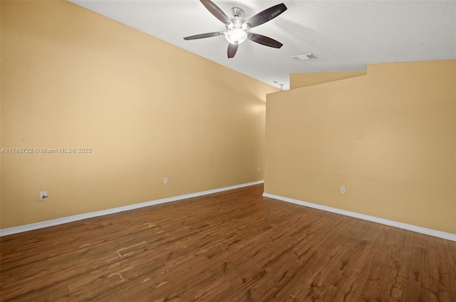 unfurnished room with ceiling fan, baseboards, lofted ceiling, dark wood-type flooring, and visible vents