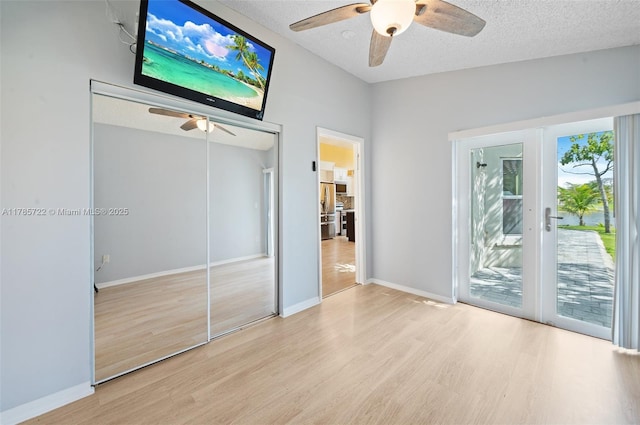 unfurnished bedroom featuring baseboards, wood finished floors, and access to exterior