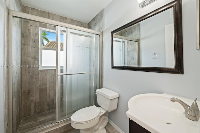 full bathroom featuring vanity, baseboards, a stall shower, and toilet
