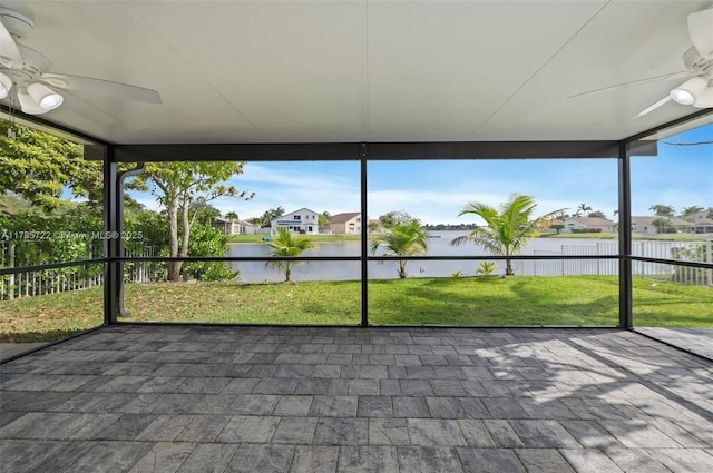 unfurnished sunroom with a water view, a residential view, and a ceiling fan