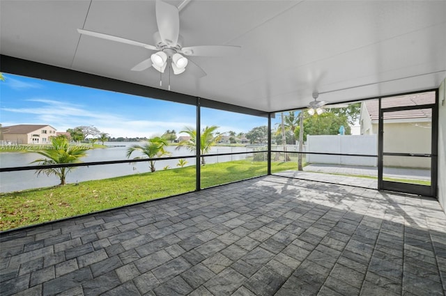 unfurnished sunroom with a water view and ceiling fan