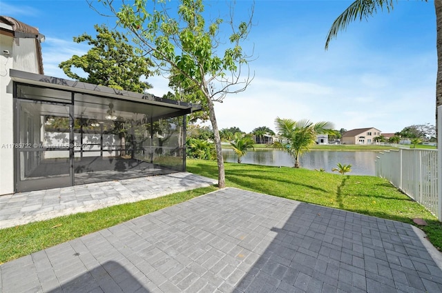 view of patio with a sunroom, a water view, and fence