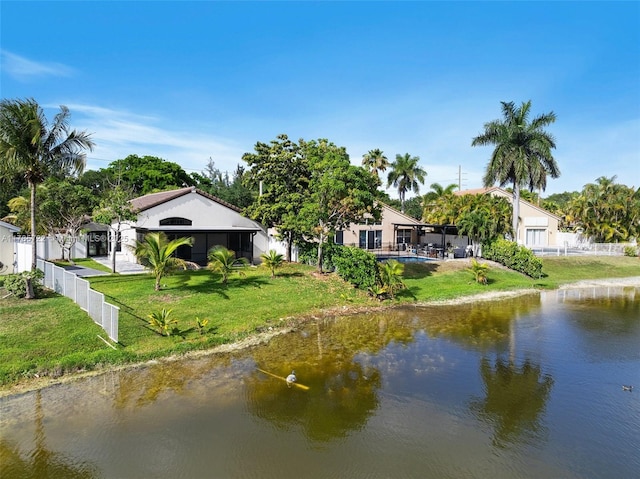 exterior space with a lawn, a water view, and fence