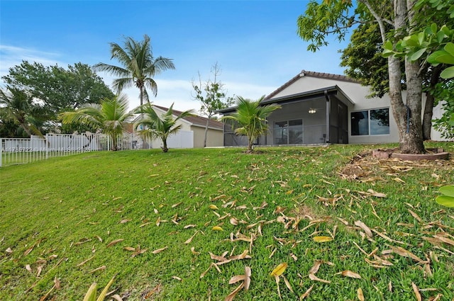 view of yard featuring fence and a sunroom