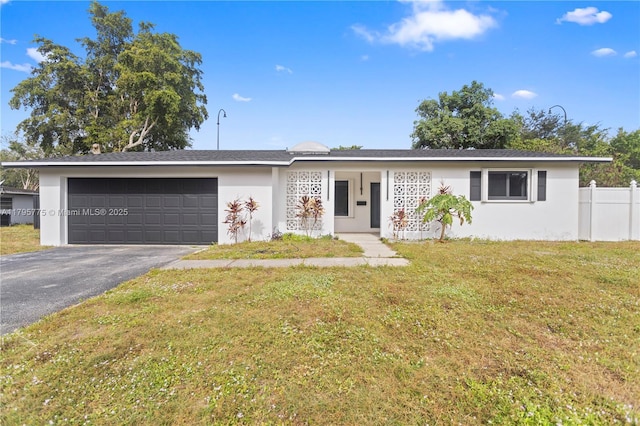 single story home with fence, an attached garage, stucco siding, a front yard, and driveway