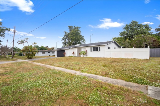 single story home with a garage, fence, a front lawn, concrete driveway, and stucco siding
