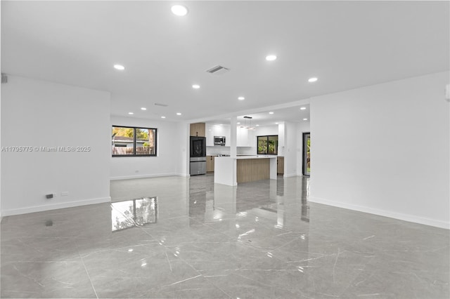 unfurnished living room with visible vents, recessed lighting, marble finish floor, and baseboards