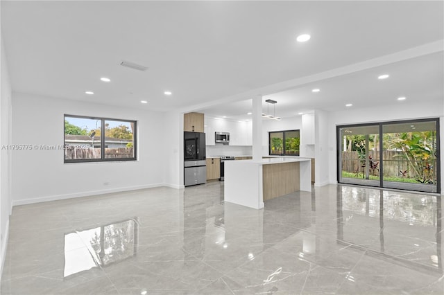 kitchen featuring plenty of natural light, marble finish floor, visible vents, and stainless steel appliances