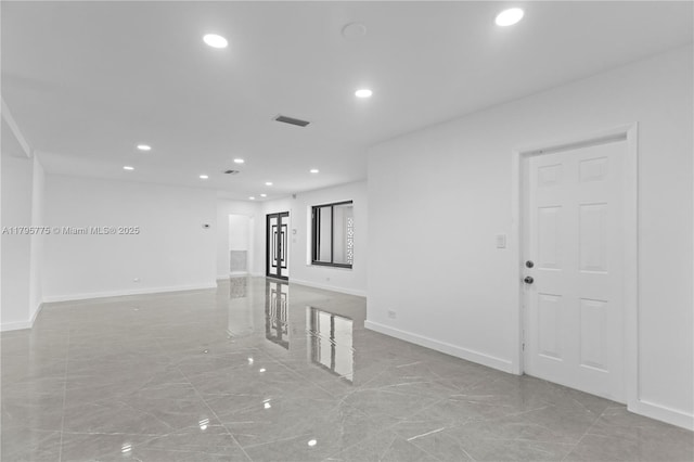 empty room with recessed lighting, baseboards, and marble finish floor