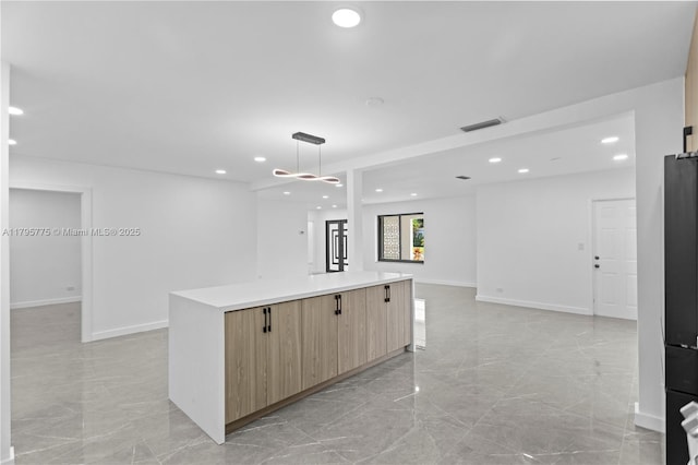 kitchen with light brown cabinetry, modern cabinets, visible vents, and marble finish floor