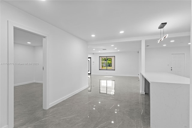 spare room featuring baseboards, recessed lighting, and marble finish floor