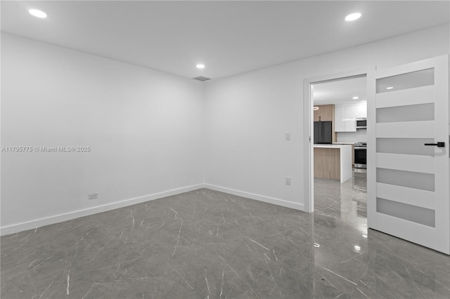 unfurnished room featuring recessed lighting, baseboards, and marble finish floor