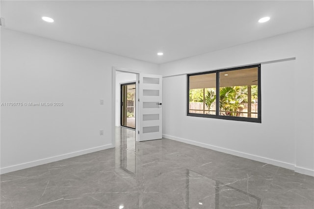 spare room with baseboards, recessed lighting, and marble finish floor