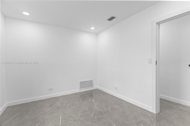 spare room with marble finish floor, recessed lighting, and visible vents