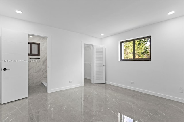 unfurnished bedroom featuring recessed lighting, baseboards, a spacious closet, and marble finish floor