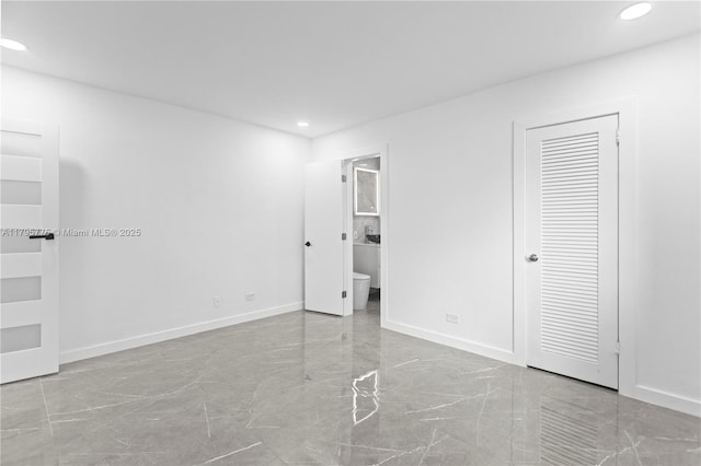 unfurnished bedroom featuring baseboards, recessed lighting, connected bathroom, and marble finish floor