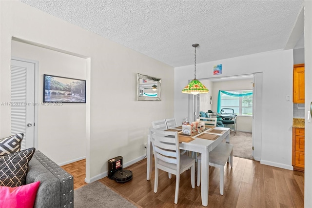 5803 NW 84th Ave, Tamarac, FL 33321 - dining space with light wood-type flooring, a textured ceiling, and baseboards