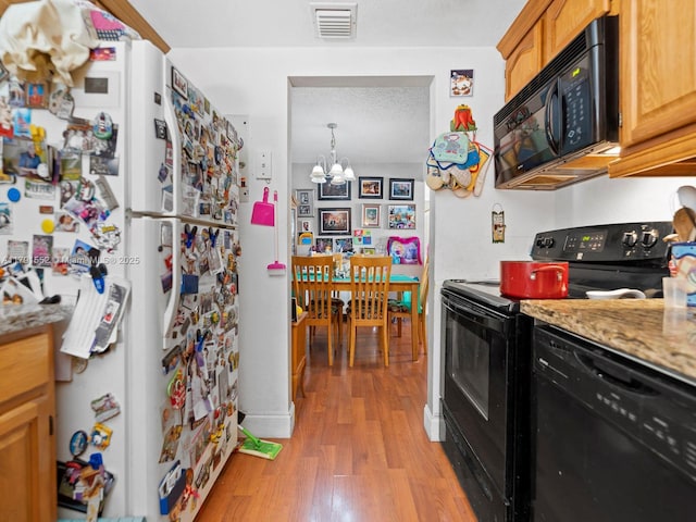 21121 SW 85th Ave Unit 202, Cutler Bay, FL 33189 - kitchen with light wood-style floors, an inviting chandelier, black appliances, and visible vents