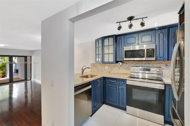 1901 NW S River Dr Unit 14-B, Miami, FL 33125 - kitchen featuring stainless steel appliances, a sink, blue cabinets, and light stone counters