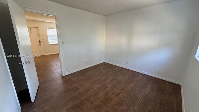 5156 NE 6th Ave Unit 205, Oakland Park, FL 33334 - spare room featuring a textured ceiling, dark wood-type flooring, and baseboards