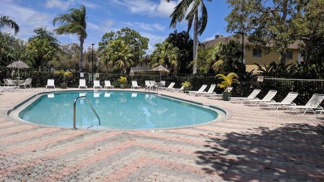 community pool featuring fence and a patio area