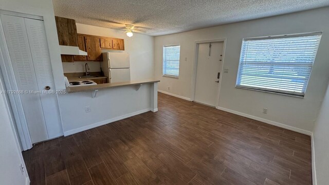 5156 NE 6th Ave Unit 205, Oakland Park, FL 33334 - kitchen with freestanding refrigerator, under cabinet range hood, a sink, ceiling fan, and a textured ceiling