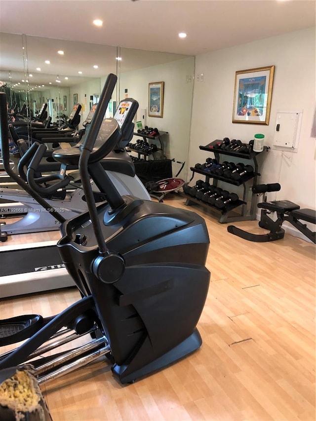 workout area with wood finished floors and recessed lighting