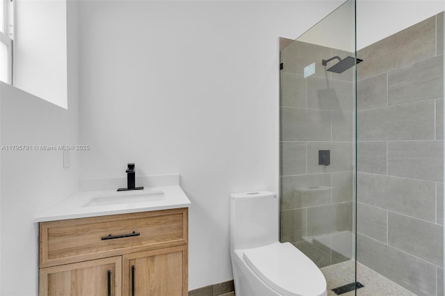 full bath with toilet, a tile shower, and vanity