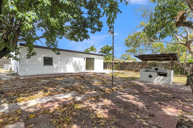 exterior space featuring stucco siding, fence, and a patio