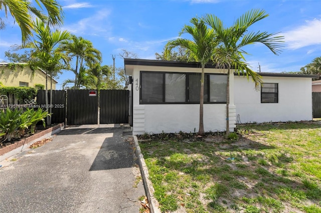 view of front of home with fence, driveway, and stucco siding