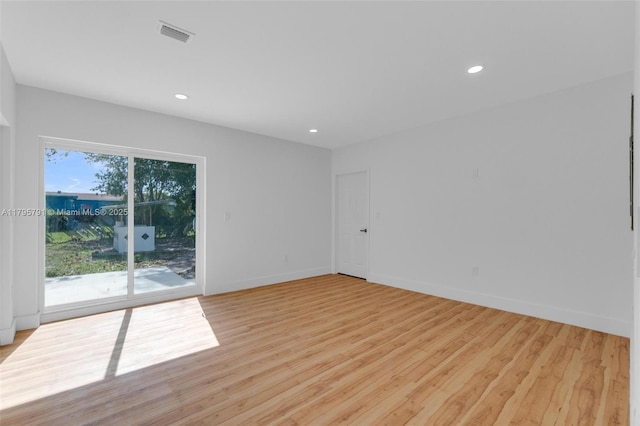 spare room with light wood-type flooring, recessed lighting, baseboards, and visible vents
