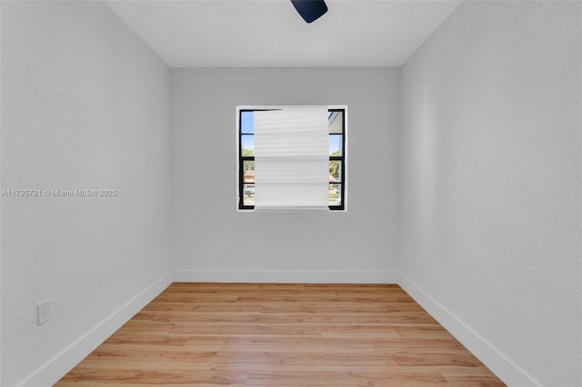 spare room featuring baseboards and light wood-style floors