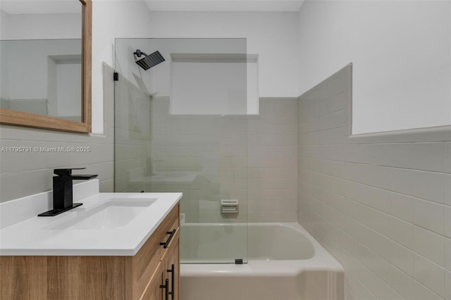 bathroom with shower / washtub combination, tile walls, and vanity